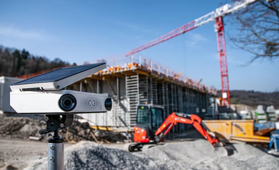 Boîtier timelapse installé sur mât télescopique face à un chantier de construction, illustration du prix d'une prestation timelapse BTP par C.lechantier